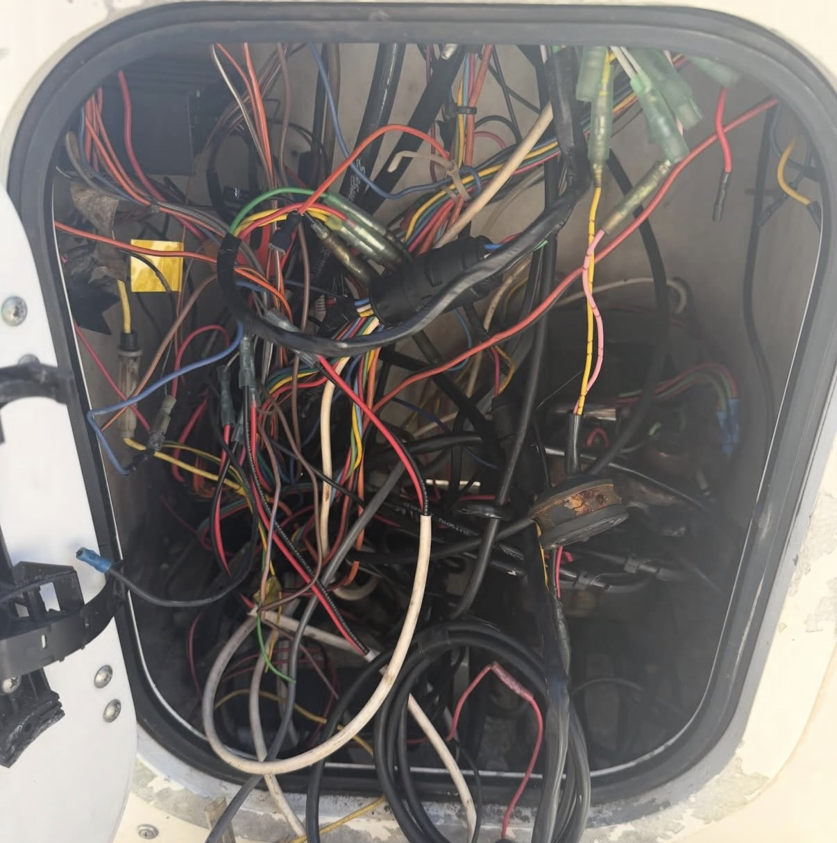 Tangled, unsecured wiring inside a boat console before service